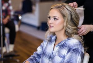 Girl getting her hair and makeup done on her wedding day