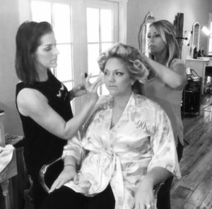 hair stylist Sarah Crews and makeup artist Mandy Davis work together on a bride at Mint Springs Farm outside Nashville Tennessee